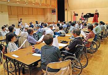 総会前の演奏会で合唱を楽しむ参加者たち