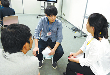 ロールプレイで不安な表情を浮かべ医師役に質問する患者さん役の原田・初期研修医（中央）