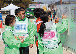 スタッフから報告を受け、状況把握に努める吉田院長と藤澤典子・看護部長（右）