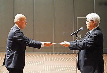 篠崎・専務理事（右）からの辞令交付に研修医は緊張した様子