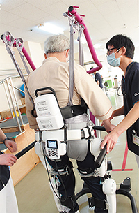 患者さんに話しかけながらリハビリを行う谷藤副主任（右）