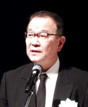 東上理事長のメッセージを読み上げる福田・副理事長